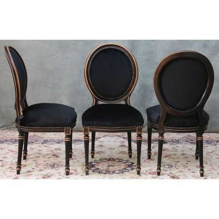 LOT 4 CHAISES MÉDAILLON - Bois noir patiné hêtre brut / Velours noirLot 4 Chaises Médaillon en stock au prix de 279€ l’unité.La finition du bois est réalisée avec un vernis noir appliqué sur le hêtre massif. Après vernissage, certaines parties et certains reliefs sont poncés manuellement à la main afin de faire réapparaître volontairement le bois brut sous la finition noire.Ce travail artisanal crée un effet patiné et légèrement vieilli, avec un contraste naturel entre le noir verni et le bois brut apparent. Cette finition est associée à un revêtement en velours noir.Caractéristiques :Style : Louis XVI / MédaillonStructure : hêtre 100% massifFabrication : renforcée pour une utilisation quotidienne ou intensiveUtilisation : particuliers, restaurants, hôtels, cafés et professionnelsRevêtement : velours noir moderneFinition : bois verni noir avec ponçage manuel faisant apparaître le bois brut par endroitsEffet : patiné et légèrement vieilliHauteur d’assise : 48/50 cmHauteur totale : 100/101 cmLargeur : 48/50cm