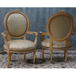 Lot 2 Fauteuils Médaillon Style Louis XVI - Bois patiné feuille d'or blanc avec un tissu crème et orMagnifique paire de fauteuils médaillon, fabriqués dans nos ateliers en bois de hêtre 100% massif. Garniture tapissier avec sangles, crin et ressorts. La teinte de bois est une patine à base de feuille d’or blanchie, offrant un effet or moderne ou ancien modernisé. Le tissu est un satin crème et doré léger.