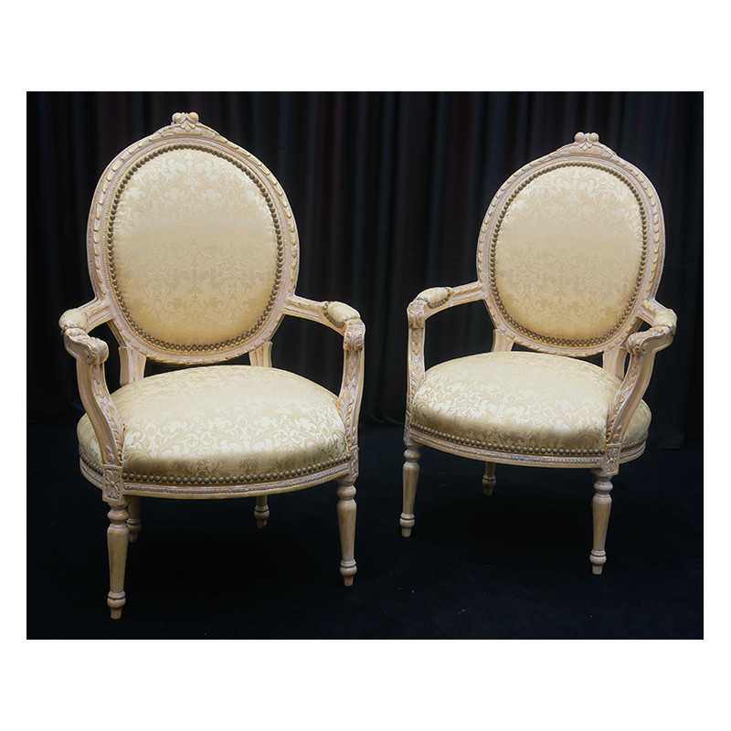 Lot 2 Fauteuils Médaillon Style Louis XVI - Bois patiné feuille d'or blanc avec un tissu crème et orMagnifique paire de fauteuils médaillon, fabriqués dans nos ateliers en bois de hêtre 100% massif. Garniture tapissier avec sangles, crin et ressorts. La teinte de bois est une patine à base de feuille d’or blanchie, offrant un effet or moderne ou ancien modernisé. Le tissu est un satin crème et doré léger.