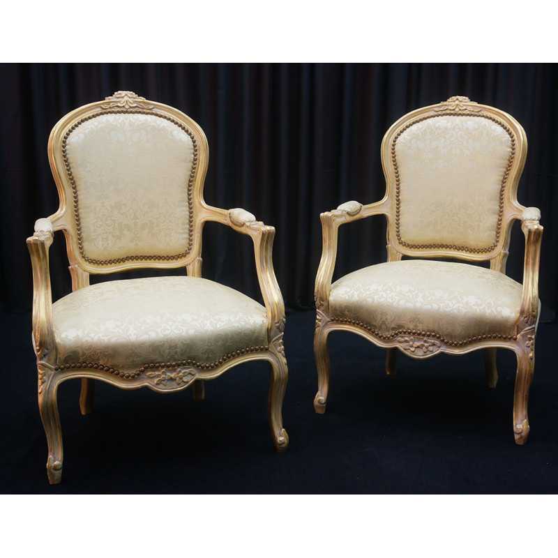 Lot 2 Fauteuils Cabriolet Style Louis XV - Bois patiné feuille d'or blanc avec un tissu crème et orMagnifique paire de fauteuils cabriolet, fabriqués dans nos ateliers en bois de hêtre 100% massif. Garniture tapissier avec sangles, crin et ressorts. La teinte de bois est une patine à base de feuille d’or blanchie, offrant un effet or moderne ou ancien modernisé. Le tissu est un satin crème et doré léger.